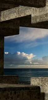 Stone arch framing ocean view with cloudy sky.