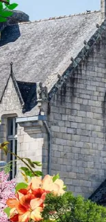 Gray stone church covered with vibrant flowers.