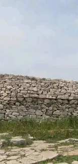 Stone wall under a cloudy sky, nature wallpaper for mobile.