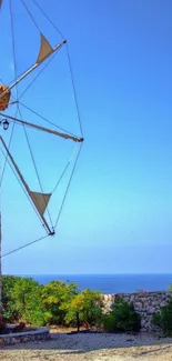 Stone windmill near a serene blue sea under a clear sky.