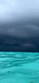 Turquoise ocean with stormy cloudy sky wallpaper.