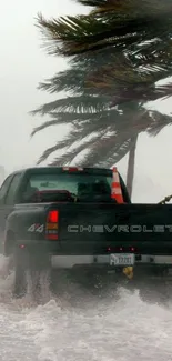 Truck driving through storm with strong winds and waves.