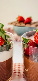 Strawberry chocolate mousse dessert in glass cups with fresh strawberry garnishes.