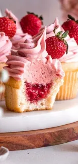 Pink strawberry cupcakes with creamy frosting and fruit topping.