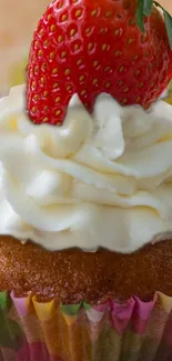 A delicious cupcake with cream and a strawberry on top.