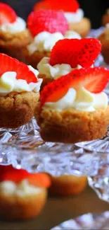 Mini tarts with strawberries on a glass stand.