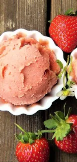 Strawberry ice cream scoops with fresh strawberries on a wooden table.