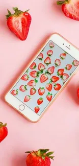 Mobile wallpaper with strawberry pattern and pink background.