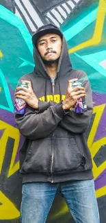 Street artist with colorful graffiti background and spray cans.