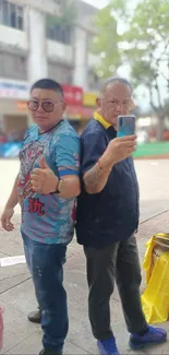 Two men posing in colorful street fashion in an urban setting.