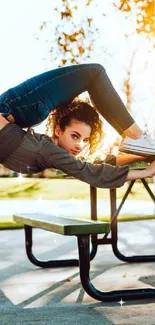 Person doing yoga on park bench in golden sunlight.