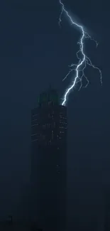 Dark skyscraper with lightning striking during a night storm.