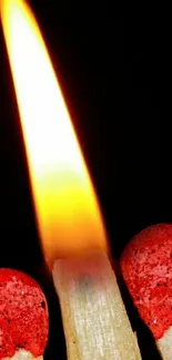 A close-up of a lit matchstick with a bright flame against a dark background.