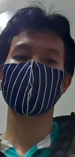 Person wearing a blue striped face mask indoors.