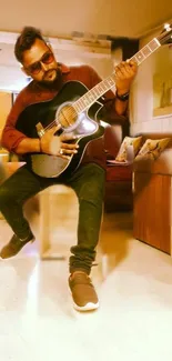 A stylish man plays guitar indoors in a chic setting.