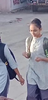 Students walking in school uniforms with backpacks on a city street.