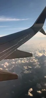 Airplane wing view above the clouds at sunset.