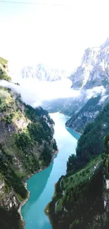 Serene alpine river valley with misty mountains and lush greenery.