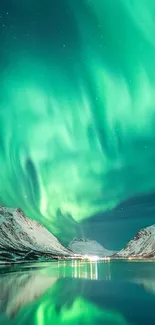 Vibrant aurora borealis over serene snowy mountains and reflective lake.