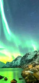 Aurora Borealis over snowy mountains at night with vibrant green sky.