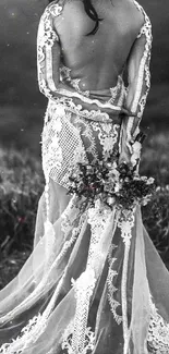 Elegant bride in a backless gown stands against a scenic backdrop in black and white.