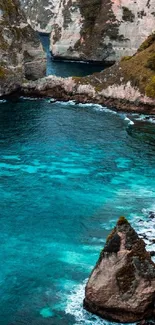 Tropical beach with turquoise water and dramatic cliffs.