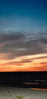 Beach sunset with vibrant colors over the ocean and serene sky.