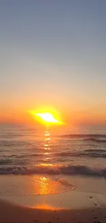 Mobile wallpaper of a stunning beach sunset with orange and blue tones over the ocean.