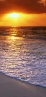 Tranquil beach sunset with orange sky and gentle ocean waves.