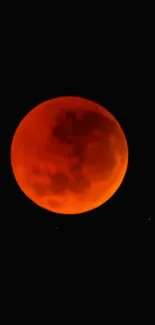 Red-orange blood moon in a dark sky wallpaper.