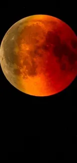 Bright red and orange blood moon against a dark sky.