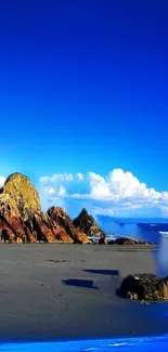 Blue beach wallpaper with rocks and clear skies, perfect for mobile screens.