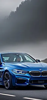 Blue car on foggy mountain road wallpaper.