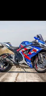 Blue sportbike on a road with scenic backdrop.