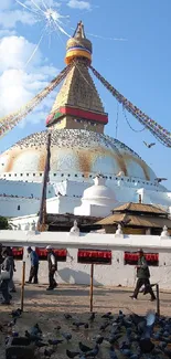 Boudhanath Stupa with colorful prayer flags under a clear blue sky.