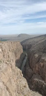 Canyon cliff view with river and sky in the background, perfect for mobile wallpaper.