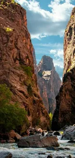 Rugged canyon landscape with a flowing river under a bright blue sky.