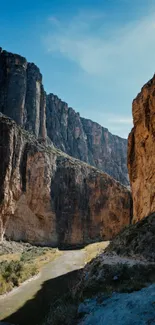 Majestic canyon wallpaper with towering rock formations and a blue sky.