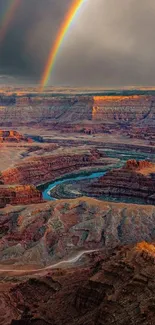 Majestic canyon landscape with a vivid rainbow overhead.