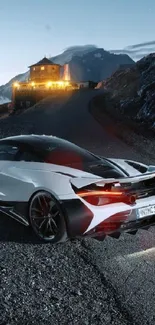 Sleek sports car on a mountain road at night.