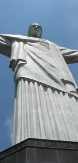 Christ the Redeemer statue under a bright blue sky with clouds.