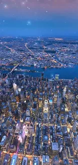 Aerial night view of a city with vibrant lights and dark blue sky.