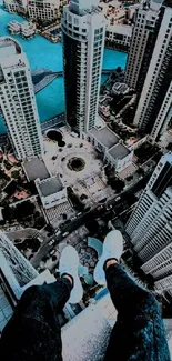 Person sitting atop skyscraper looking down at cityscape.