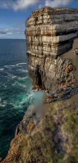 Majestic ocean waves against towering cliffs under a blue sky.