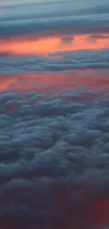 Vibrant sunset above clouds with red and blue hues.