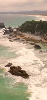 Turquoise coastal beach with waves and rocky cliffs.