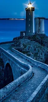 Lighthouse on a rocky coast with a blue ocean backdrop.