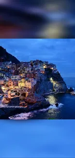 Coastal town illuminated at night with blue sea and sky.