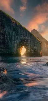 Coastal rock formation at sunset with ocean waves and vibrant sky.