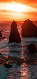 Vivid orange coastal sunset with striking rock formations.